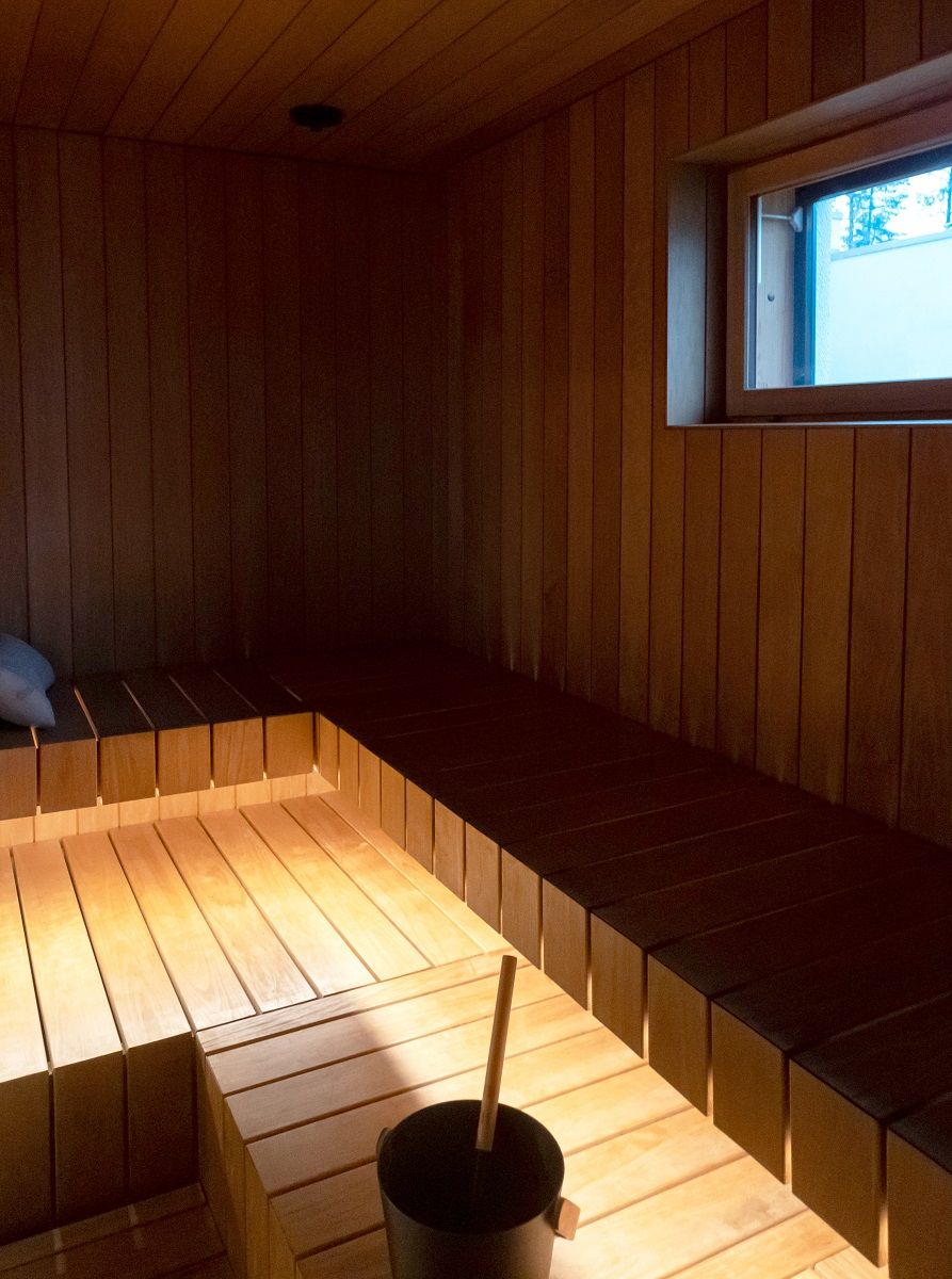 At the front edge of the seating area, a LED strip in a warm shade of 3 000 K as indirect light illuminates the wooden boards.